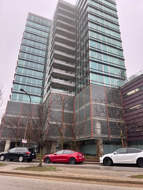 a view of a building and car parked on road