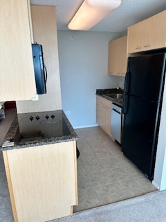 800 Elgin Road, Unit 1404 Evanston, IL 60201 - Photo 4 of 8 a kitchen with granite countertop a refrigerator stove and microwave