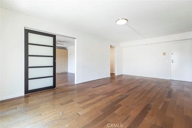 a view of a room with wooden floor and white walls