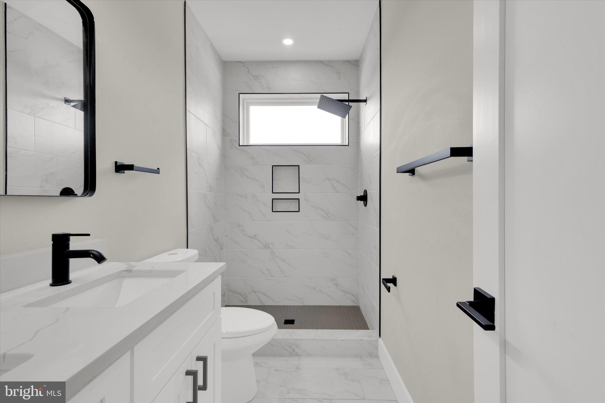 1915 Benning Road Northeast, Unit 2 Washington, DC 20002 - Photo 10 of 17 a bathroom with a sink a toilet and shower