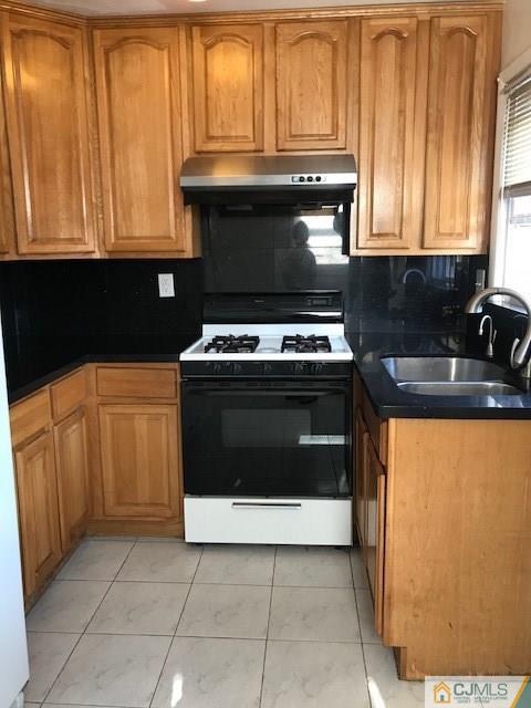 21 Kendall Road East Brunswick, NJ 08816 - Photo 7 of 21 a kitchen with granite countertop a stove top oven cabinetry and a sink