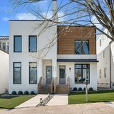 a front view of a house with a yard and potted plants
