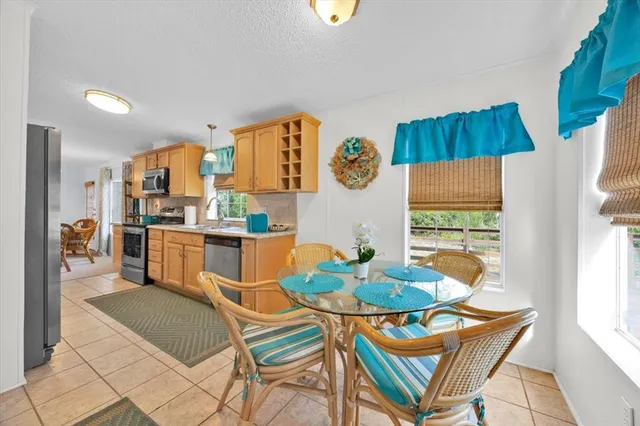 a kitchen with stainless steel appliances kitchen island granite countertop a refrigerator and a dining table