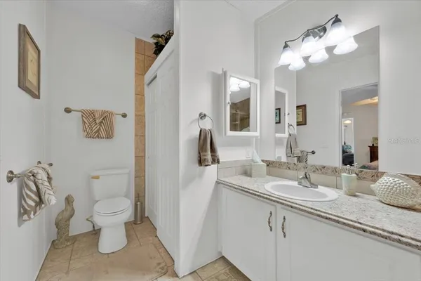 a bathroom with a granite countertop sink a toilet and a mirror