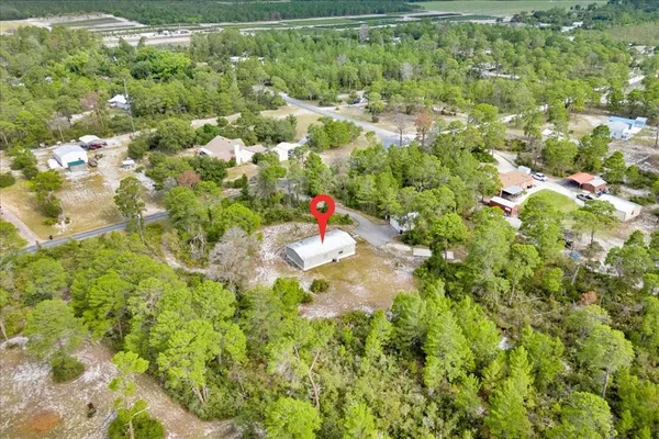 an aerial view of a residential houses with yard