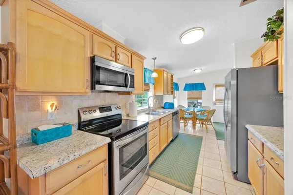 a kitchen with granite countertop a refrigerator a stove top oven a sink and dishwasher