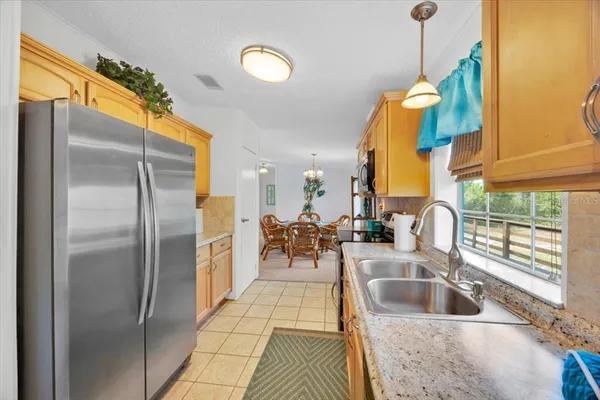 a kitchen with stainless steel appliances granite countertop a sink and a refrigerator