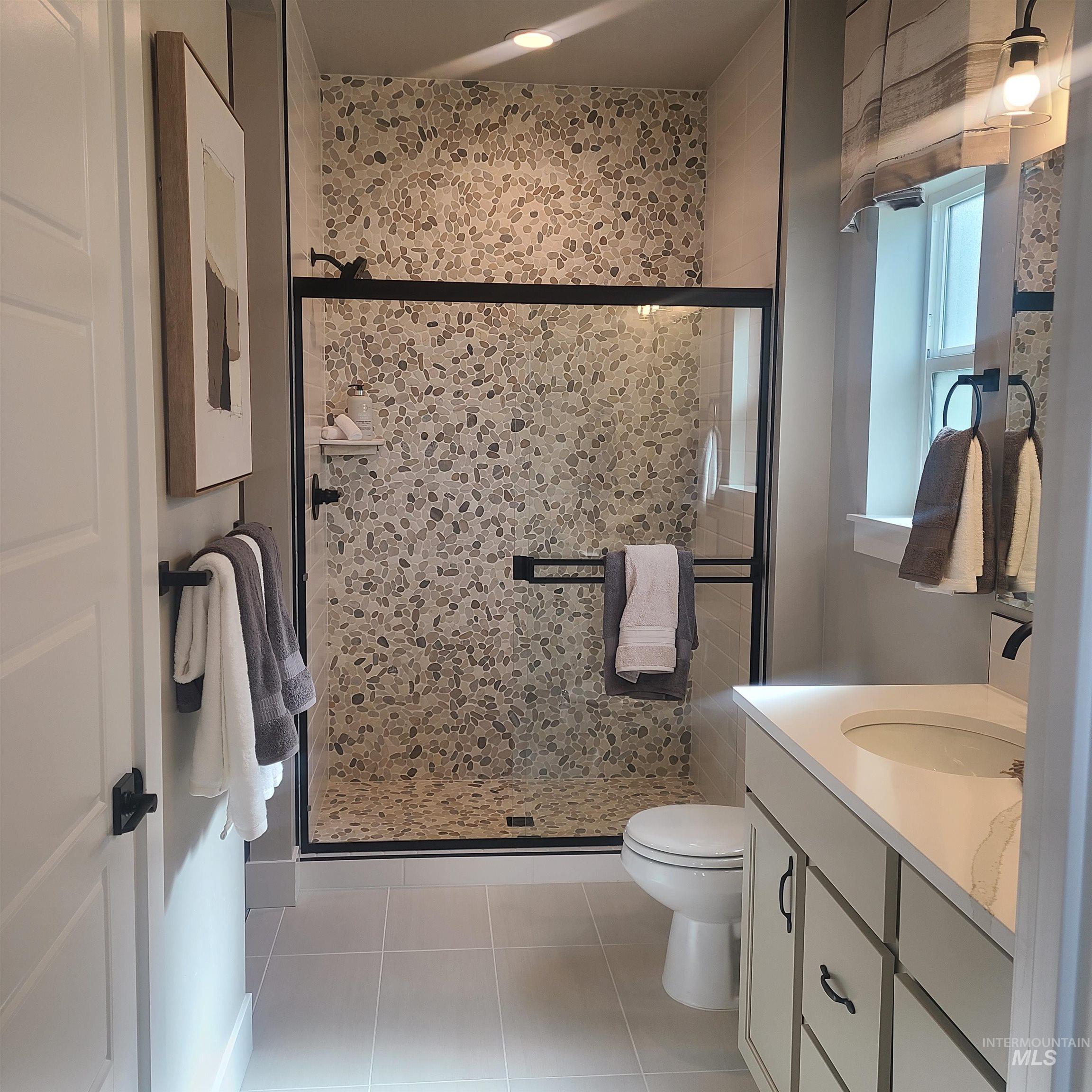 447 South Jake Avenue Kuna, ID 83634 - Photo 6 of 14 Full bathroom with a stall shower, vanity, and light tile patterned floors