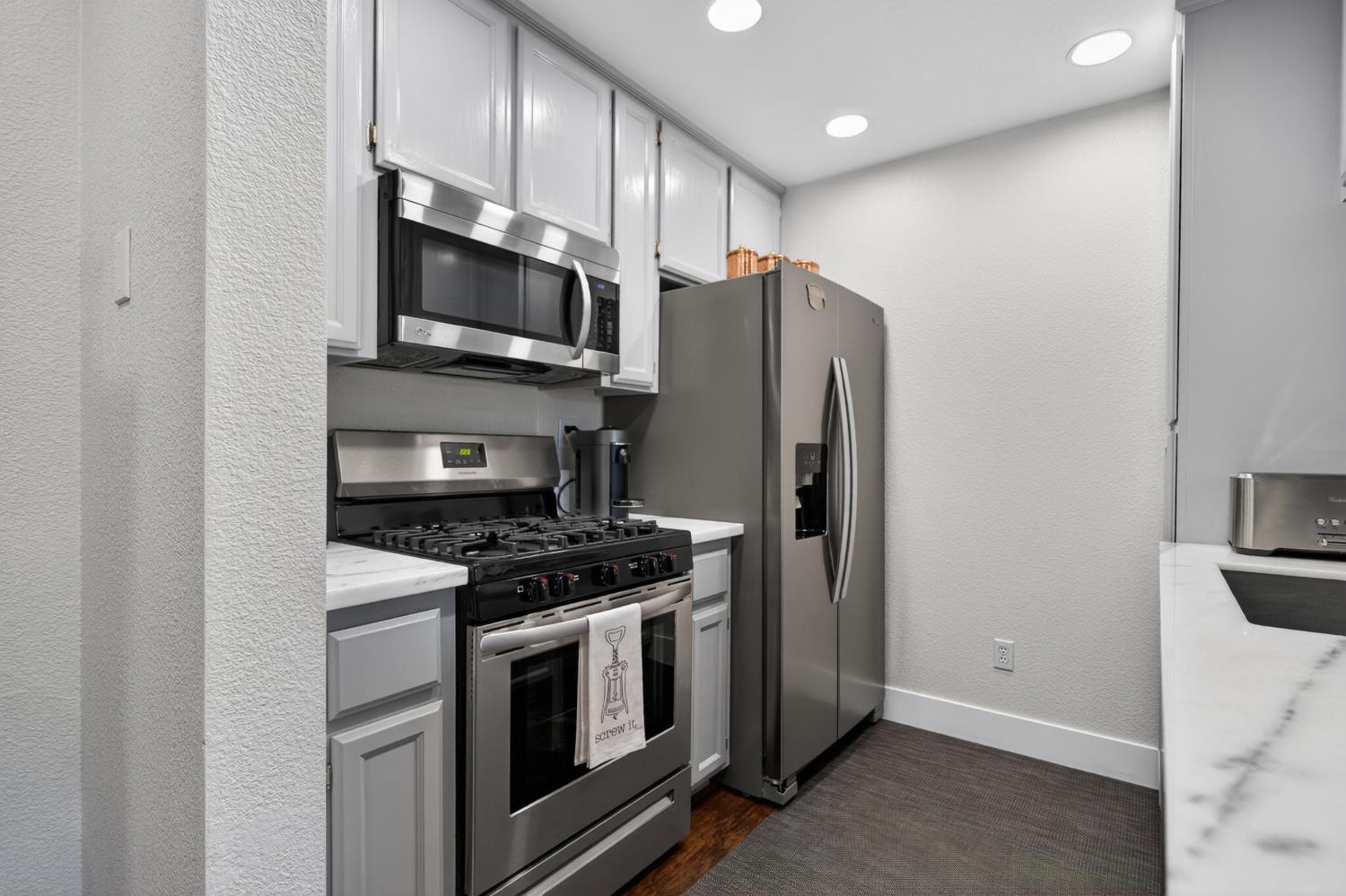 8020 Walerga Road, Unit 1140 Antelope, CA 95843 - Photo 14 of 37 a kitchen with stainless steel appliances granite countertop a stove a refrigerator and a microwave