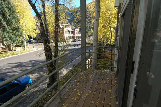 a view of a balcony with a yard