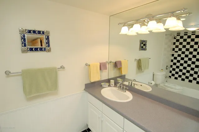a bathroom with a sink a mirror and a shower