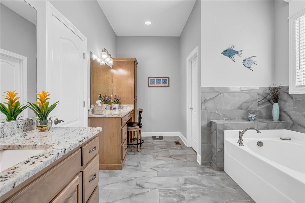 667 Rutherford Lane Smithville, TN 37166 - Photo 44 of 89 a bathroom with a granite countertop sink a mirror and a bathtub