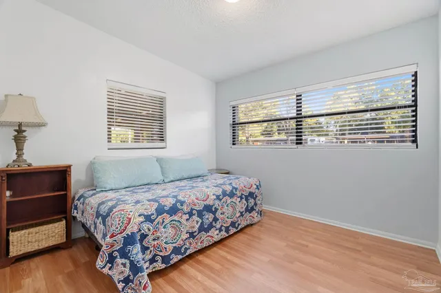 a bedroom with a bed wooden floor and window