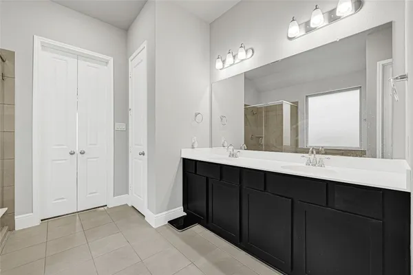 a bathroom with a double vanity sink and a mirror