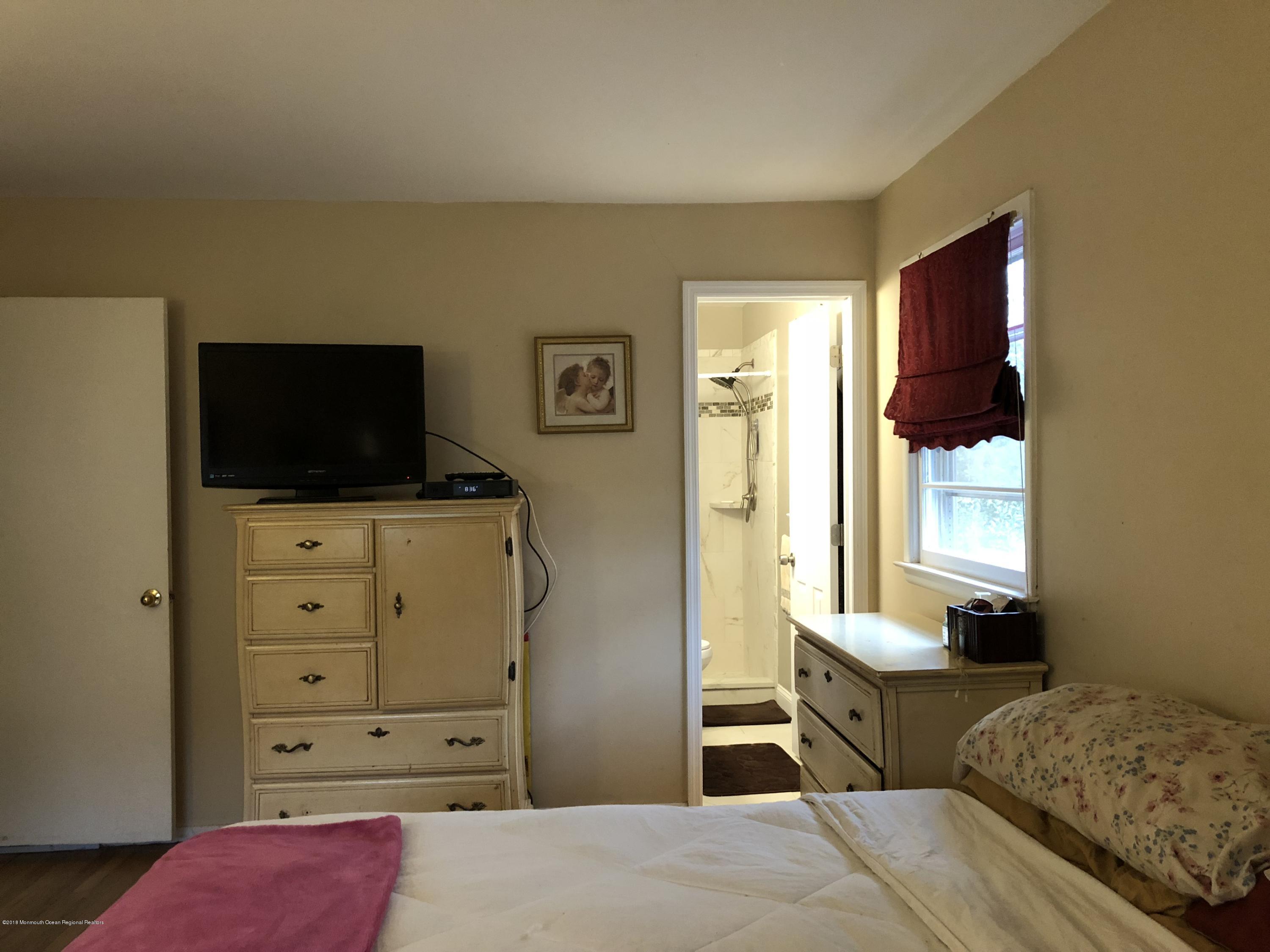 100 Sargent Road Freehold, NJ 07728 - Photo 18 of 30 a bedroom with a bed and flat tv screen on dresser