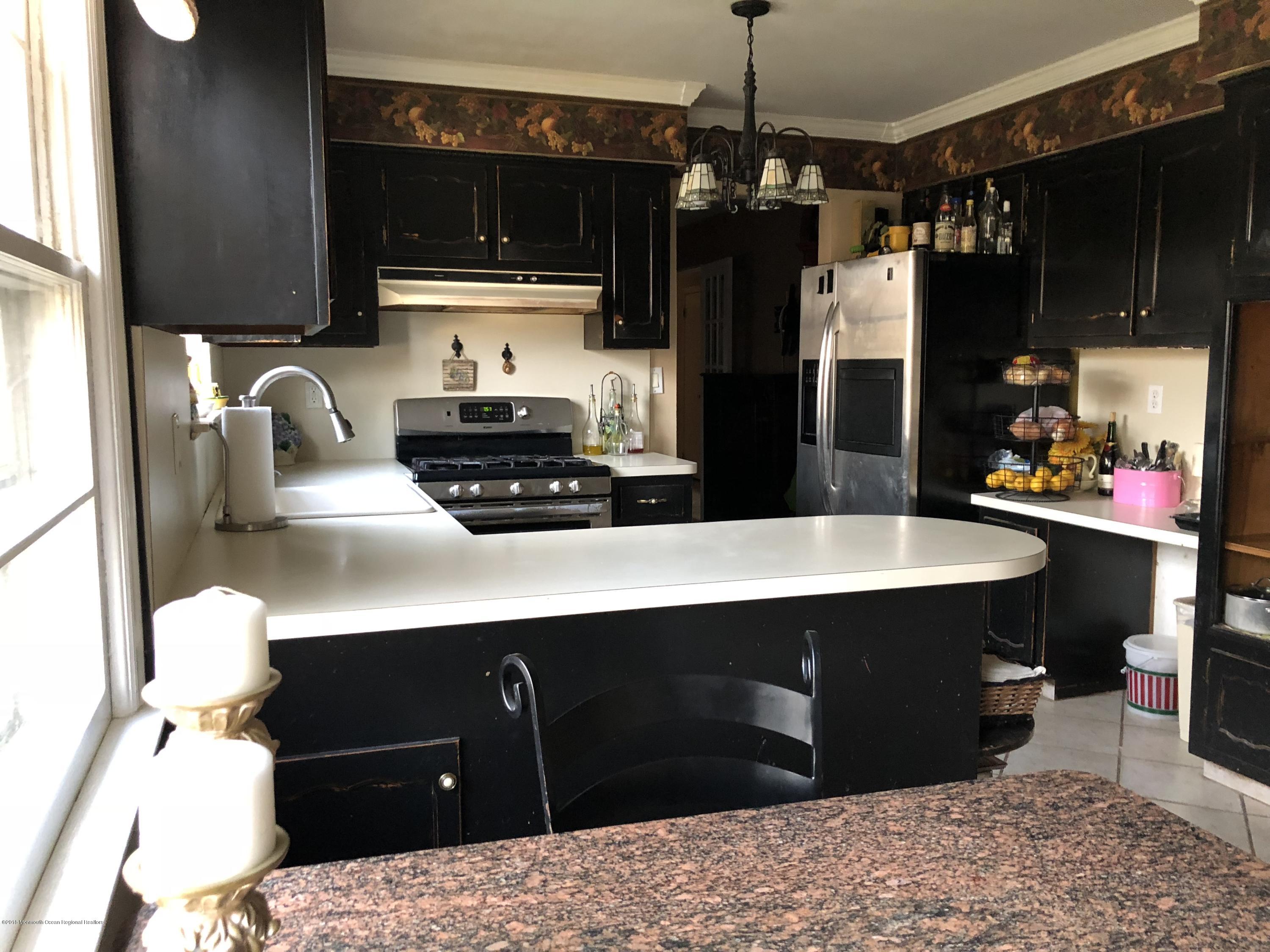 100 Sargent Road Freehold, NJ 07728 - Photo 9 of 30 a kitchen with a sink refrigerator and cabinets