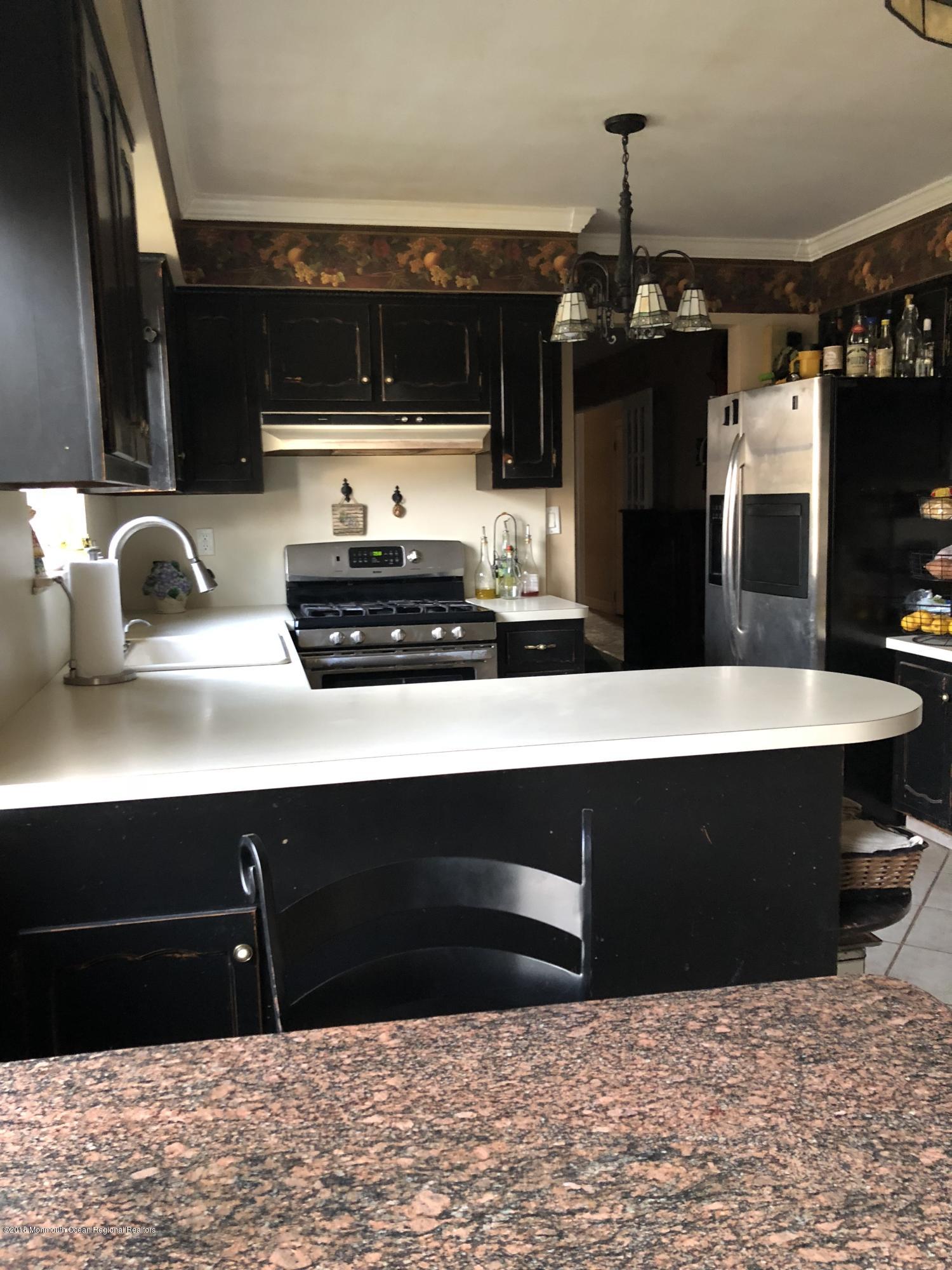 100 Sargent Road Freehold, NJ 07728 - Photo 10 of 30 a kitchen with stainless steel appliances a stove a sink a microwave a refrigerator and cabinets