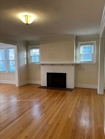 a view of empty room with wooden floor and fireplace