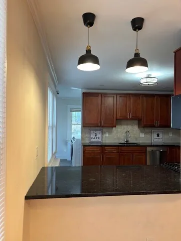 a kitchen with stainless steel appliances granite countertop a stove a sink and a refrigerator