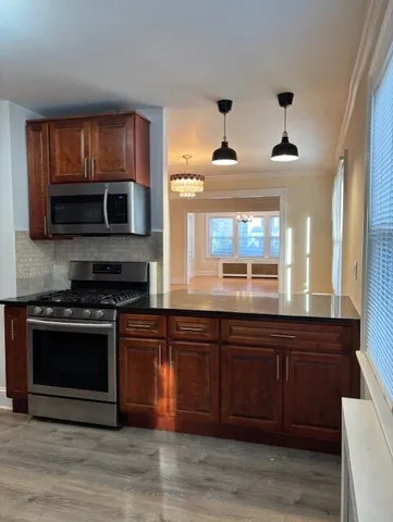 a kitchen with stainless steel appliances wooden cabinets and a stove top oven