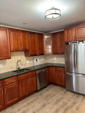 a kitchen with stainless steel appliances granite countertop a sink refrigerator and cabinets