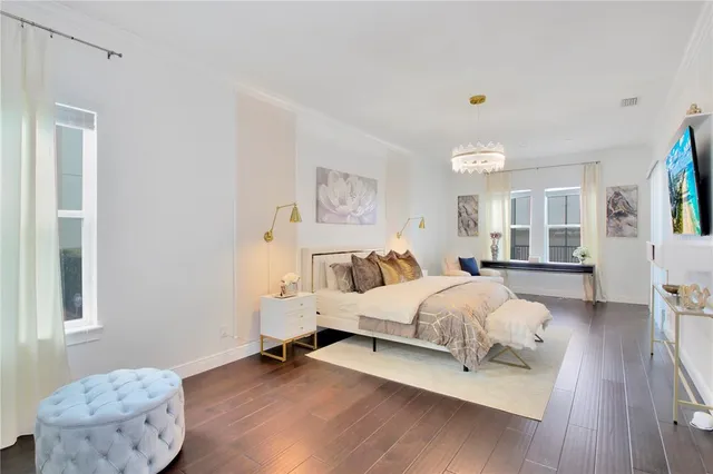 a spacious bedroom with a bed and wooden floor
