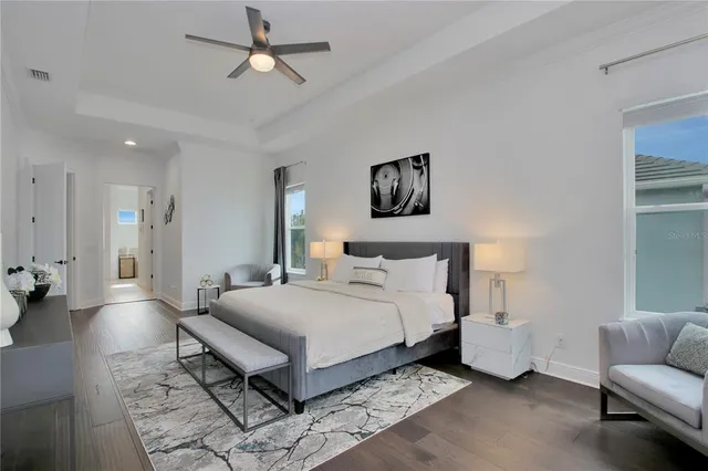 a spacious bedroom with a bed a couch and a chandelier