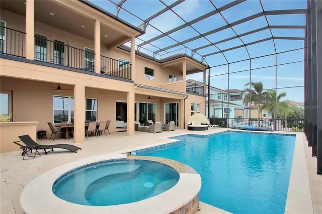 a view of a house with swimming pool and sitting area