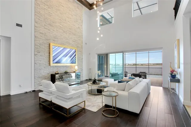 a living room with furniture floor to ceiling window and wooden floor