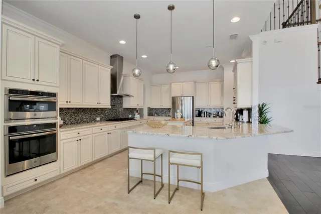 a kitchen with stainless steel appliances kitchen island granite countertop a stove a sink and a refrigerator