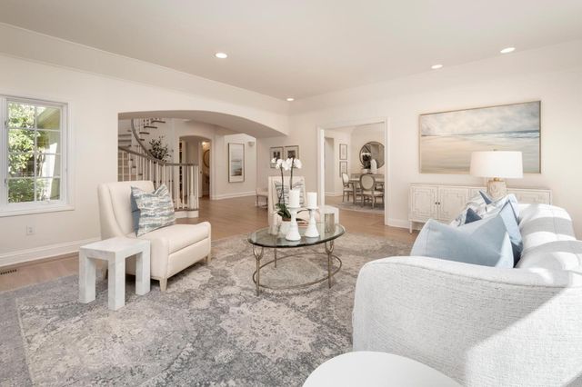 a living room with furniture fireplace and a large window