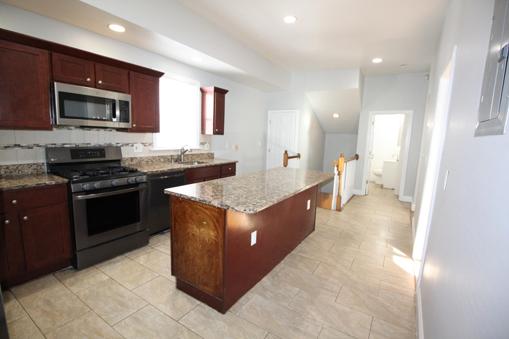 83 Devon Street, Unit 1 Boston, MA 02121 - Photo 5 of 21 a kitchen with stainless steel appliances granite countertop a stove a sink and a microwave