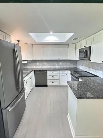 a kitchen with stainless steel appliances granite countertop a refrigerator sink and stove