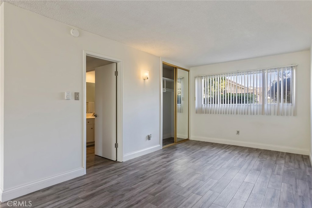 23033 Maple Avenue, Unit A Torrance, CA 90505 - Photo 18 of 45 an empty room with wooden floor and windows
