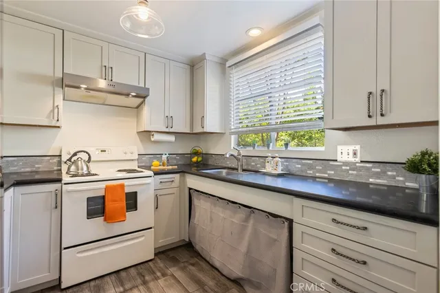 a kitchen with a sink stove and cabinets