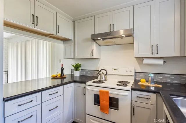 a kitchen with white cabinets and white appliances