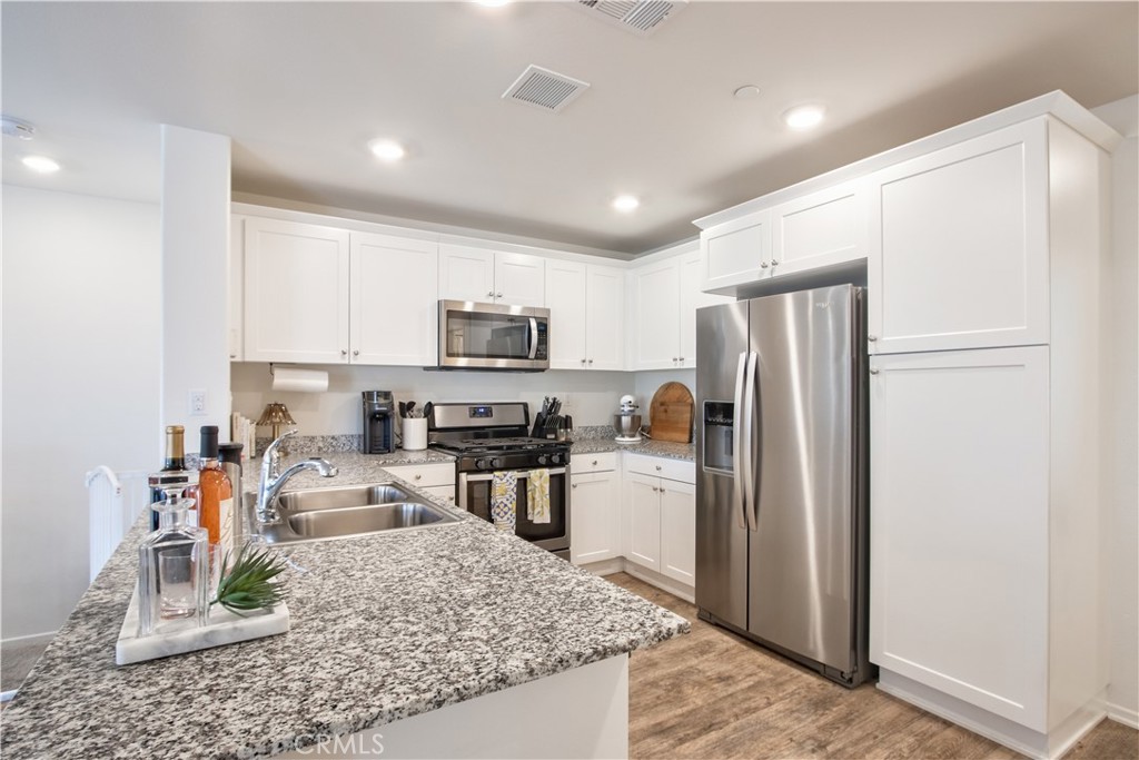 28397 Partridge Way, Unit 1001 Murrieta, CA 92563 - Photo 16 of 47 a kitchen with stainless steel appliances granite countertop a refrigerator stove microwave and sink