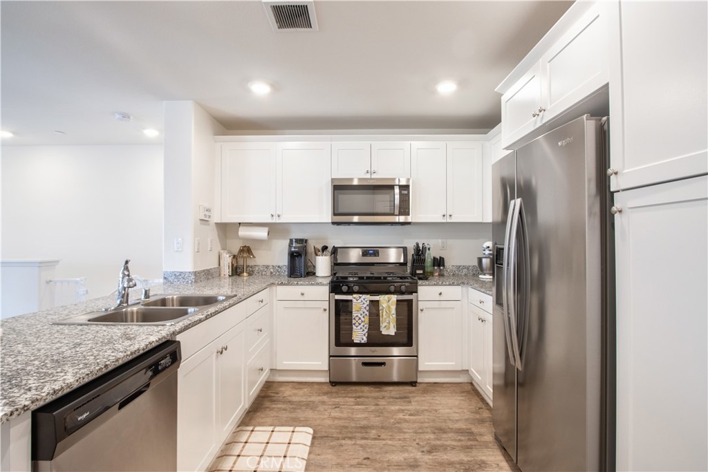 28397 Partridge Way, Unit 1001 Murrieta, CA 92563 - Photo 17 of 47 a kitchen with a sink a refrigerator a microwave and cabinets
