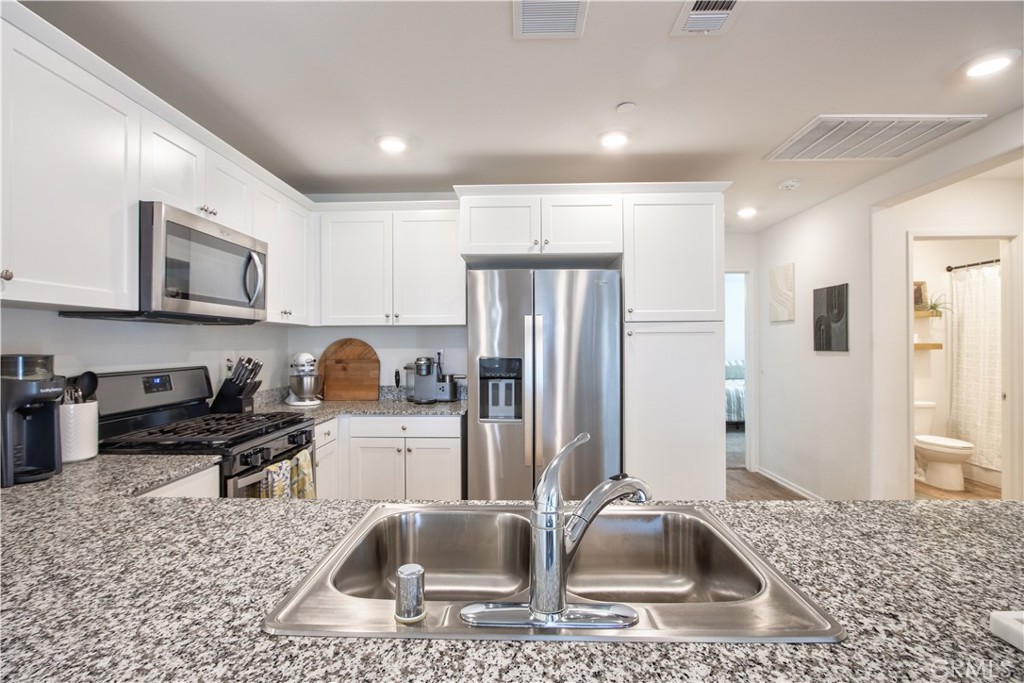 28397 Partridge Way, Unit 1001 Murrieta, CA 92563 - Photo 19 of 47 a kitchen with stainless steel appliances granite countertop a sink refrigerator and stove