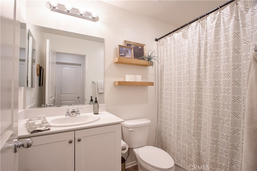 28397 Partridge Way, Unit 1001 Murrieta, CA 92563 - Photo 26 of 47 a bathroom with a sink a toilet and shower curtain