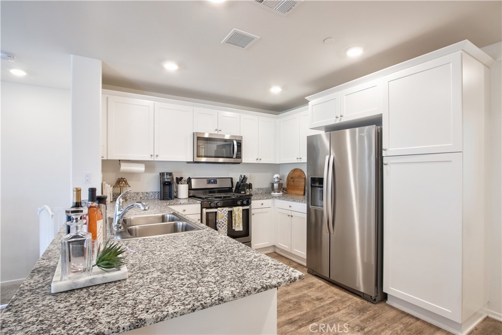 28397 Partridge Way, Unit 1001 Murrieta, CA 92563 - Photo 41 of 47 a kitchen with stainless steel appliances granite countertop a refrigerator stove microwave and sink