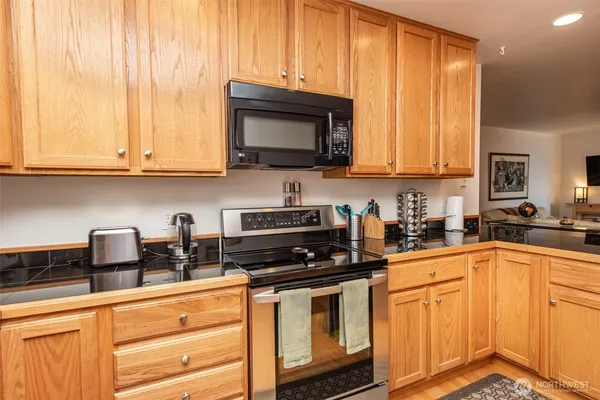 a kitchen with stainless steel appliances granite countertop a stove a sink and a microwave