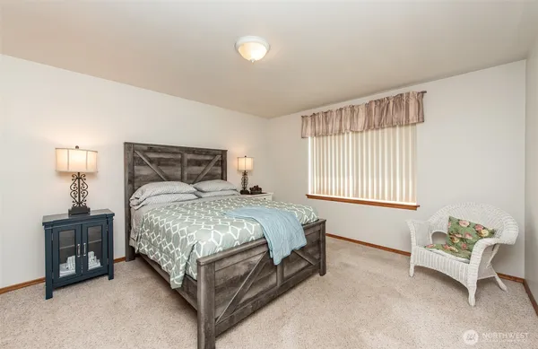 a bed room with a bed and a chair
