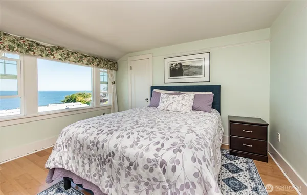 a view of a room that has a bed window and a table in it