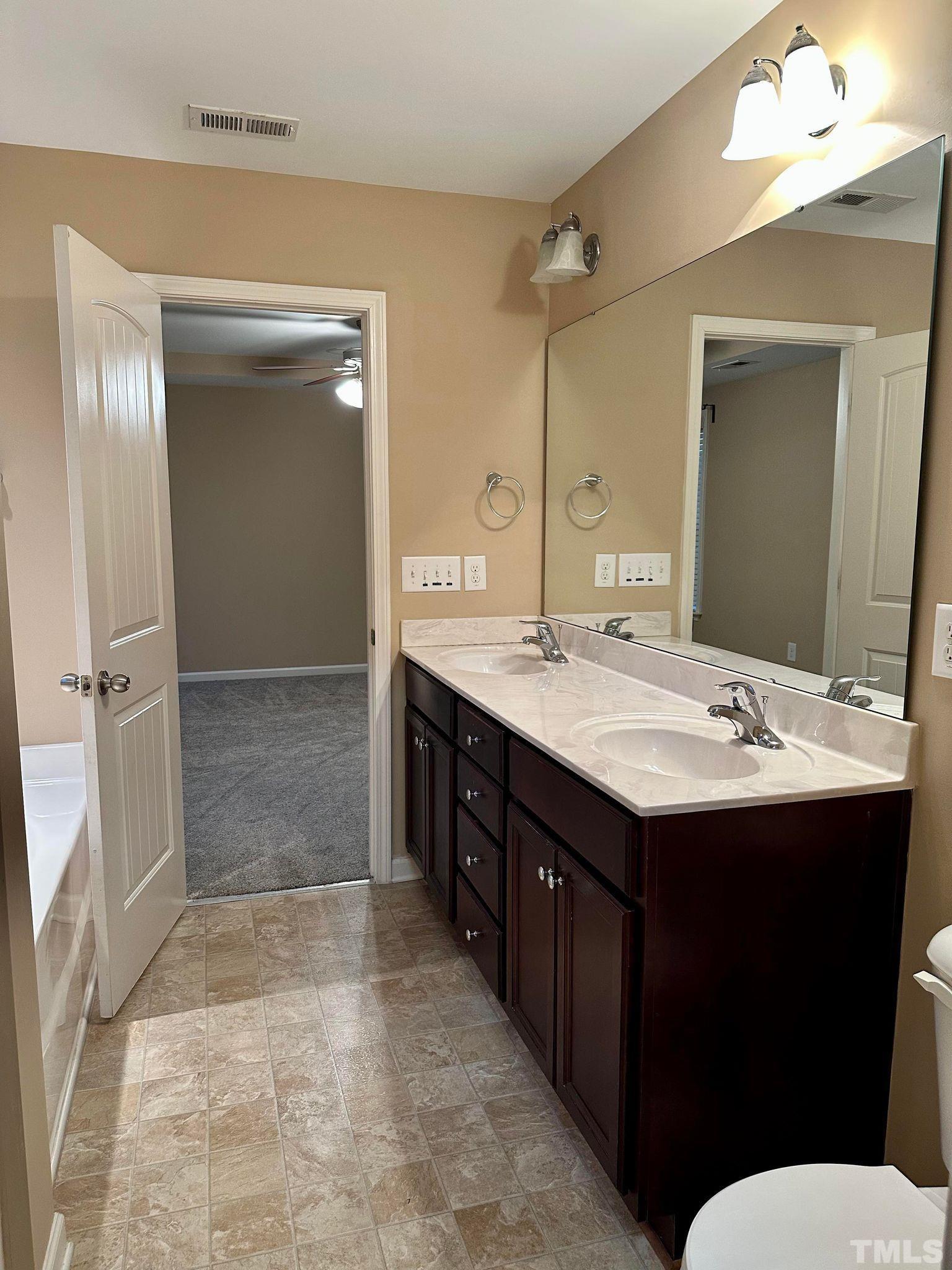 144 Bicentennial Way Cameron, NC 28326 - Photo 13 of 27 a bathroom with a double vanity sink and mirror