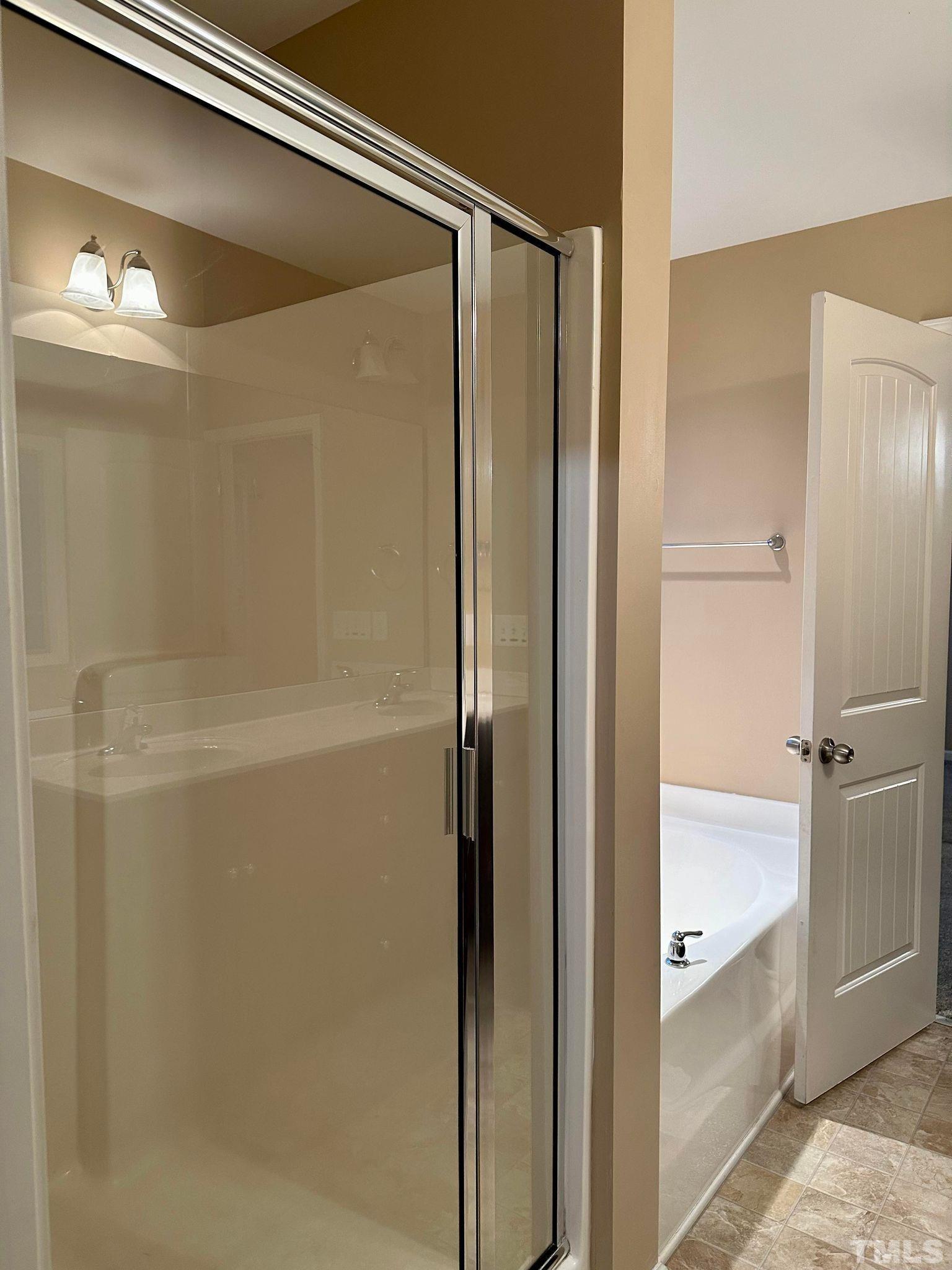 144 Bicentennial Way Cameron, NC 28326 - Photo 15 of 27 a bathroom with a glass shower door and a bathtub