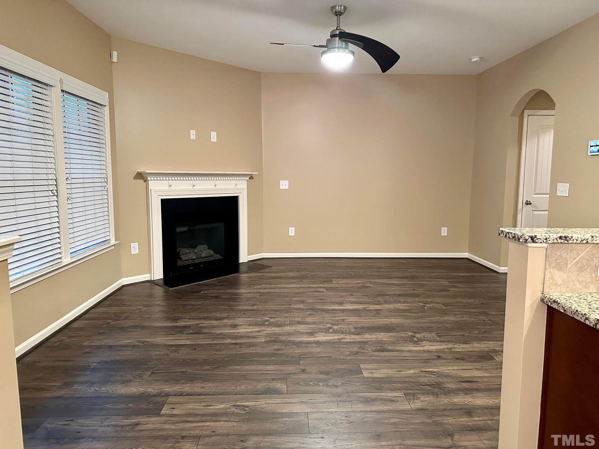 144 Bicentennial Way Cameron, NC 28326 - Photo 5 of 27 an empty room with wooden floor fireplace and windows