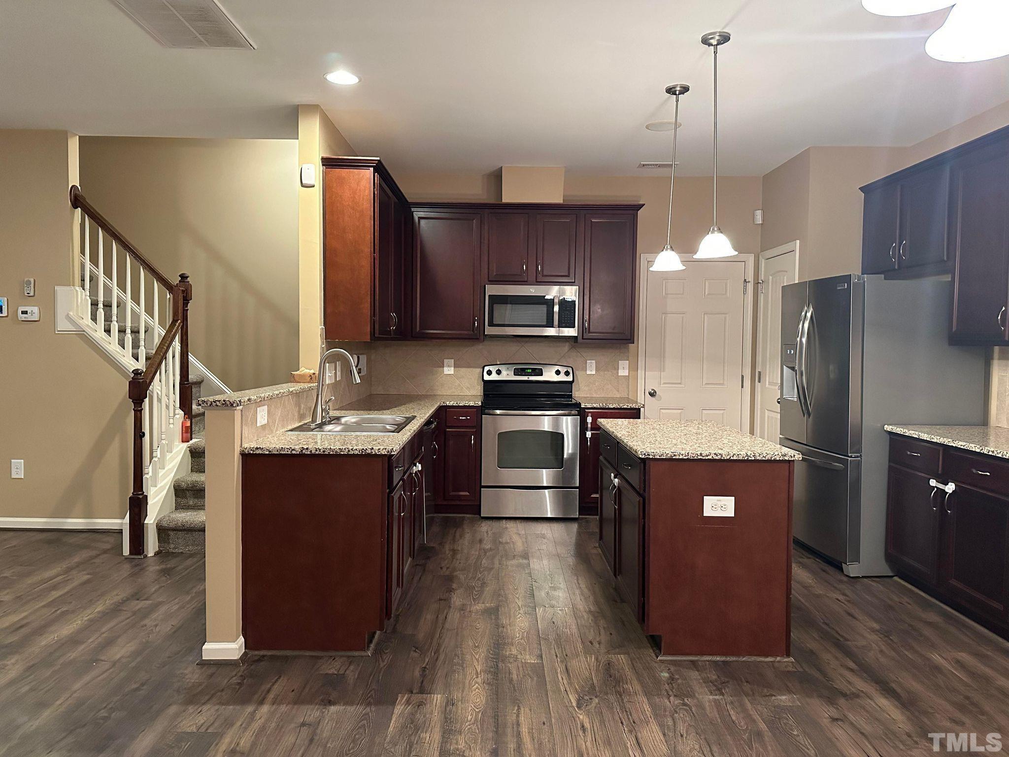 144 Bicentennial Way Cameron, NC 28326 - Photo 6 of 27 a kitchen with stainless steel appliances granite countertop a stove a sink dishwasher a refrigerator and a oven with wooden floor