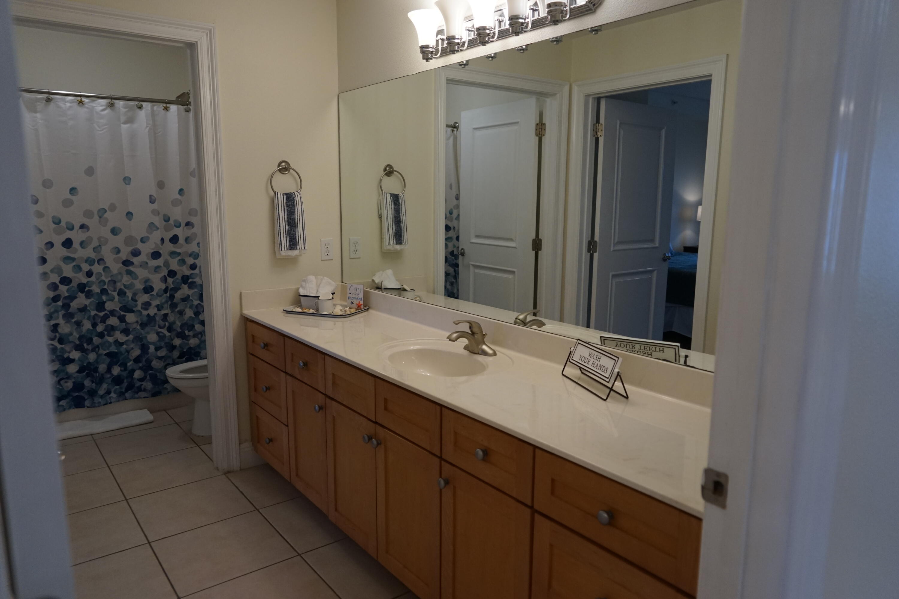 43 Cassine Way, Unit 402 Santa Rosa Beach, FL 32459 - Photo 11 of 52 a bathroom with a double vanity sink a toilet and a mirror