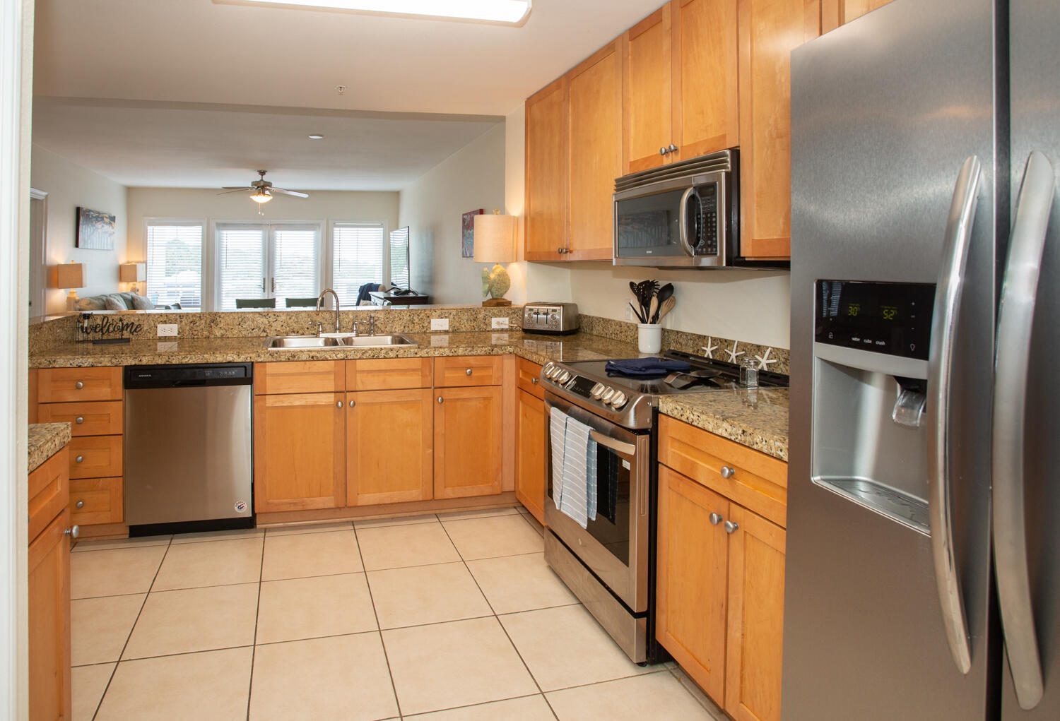 43 Cassine Way, Unit 402 Santa Rosa Beach, FL 32459 - Photo 22 of 52 a kitchen with stainless steel appliances granite countertop a stove top oven a sink dishwasher and a refrigerator